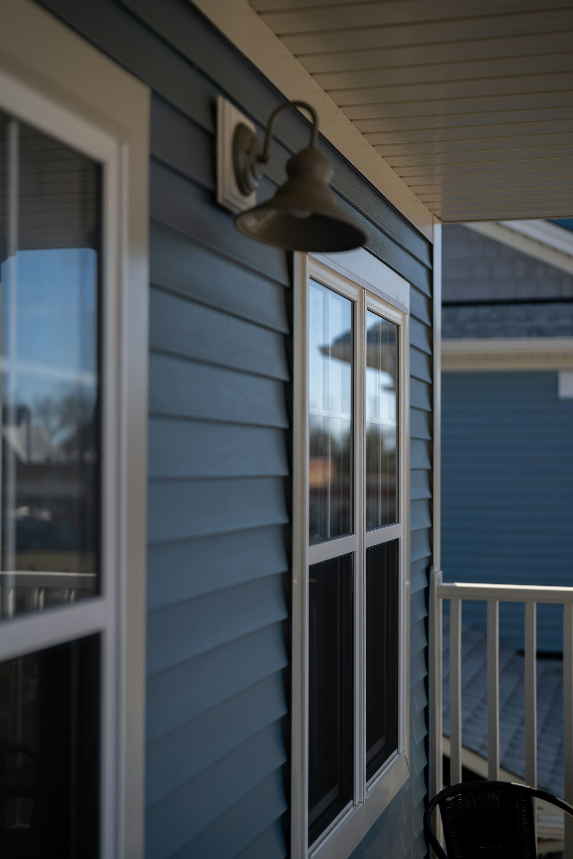 Blue lap siding with white trim and an exterior light