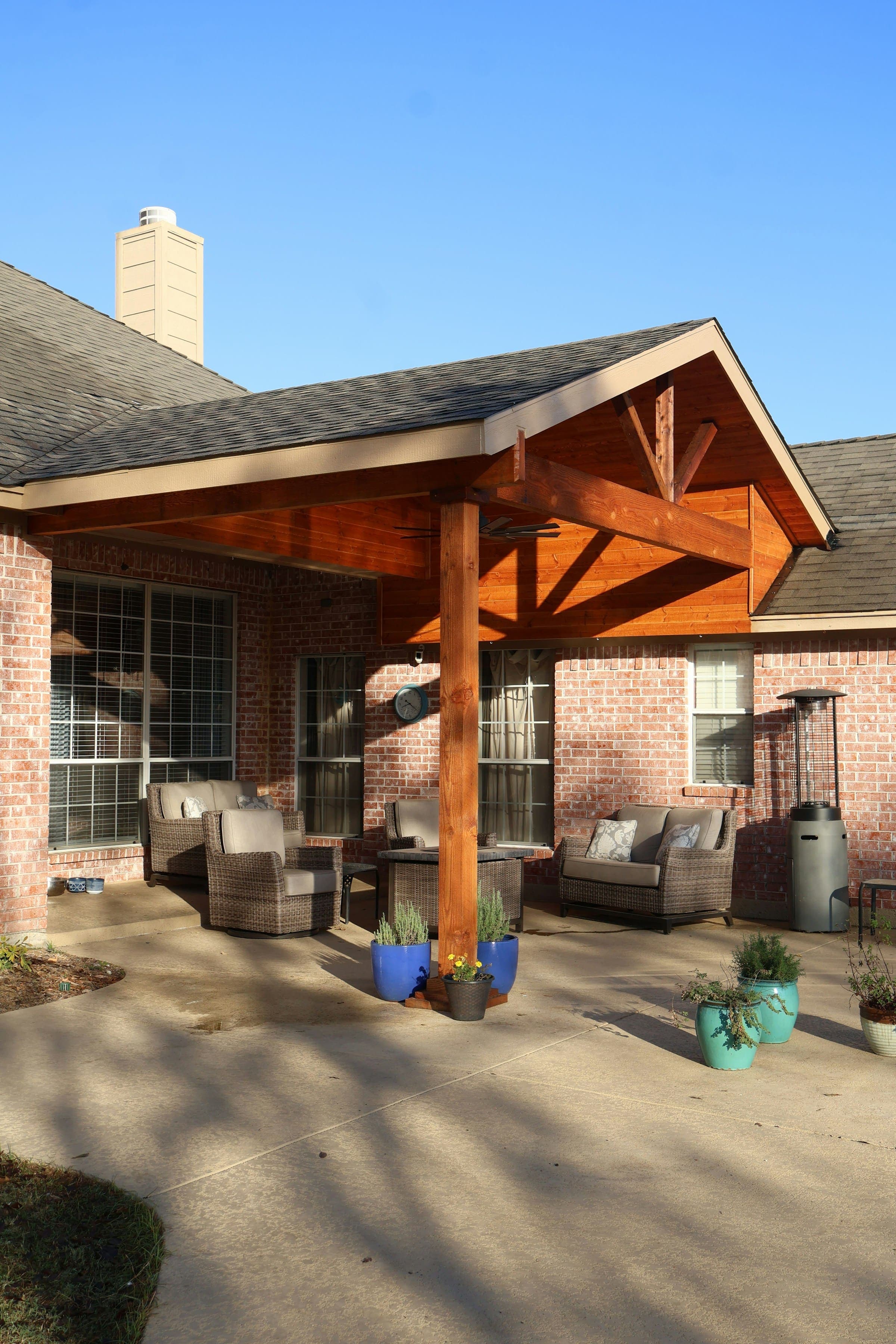 Brick home with a cedar-framed covered patio under a gabled roof