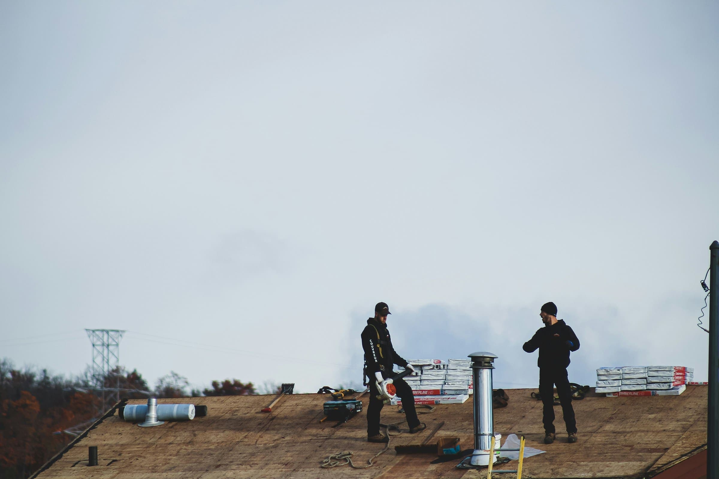 Two roofers working on a flat commercial roof