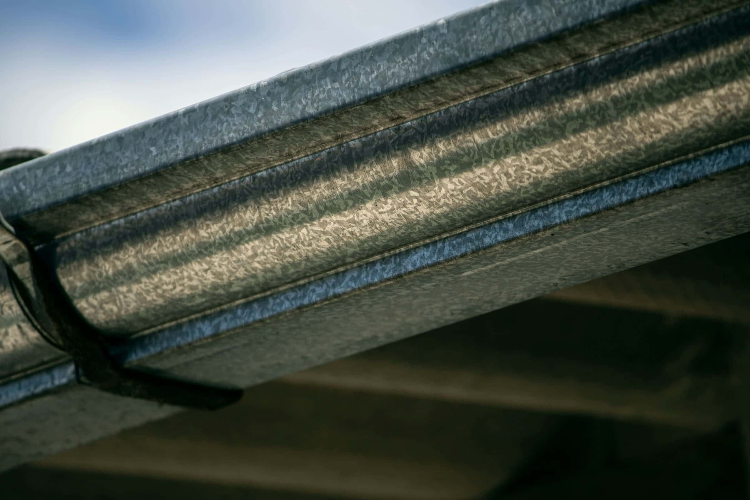 Close-up of a metal gutter along a shingle roof edge