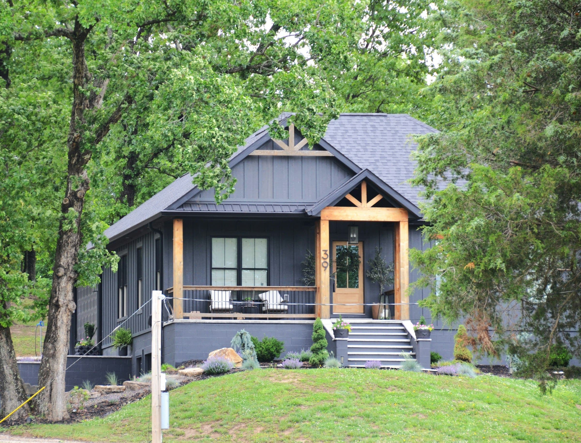 Dark gray modern home with board-and-batten siding and a timber porch