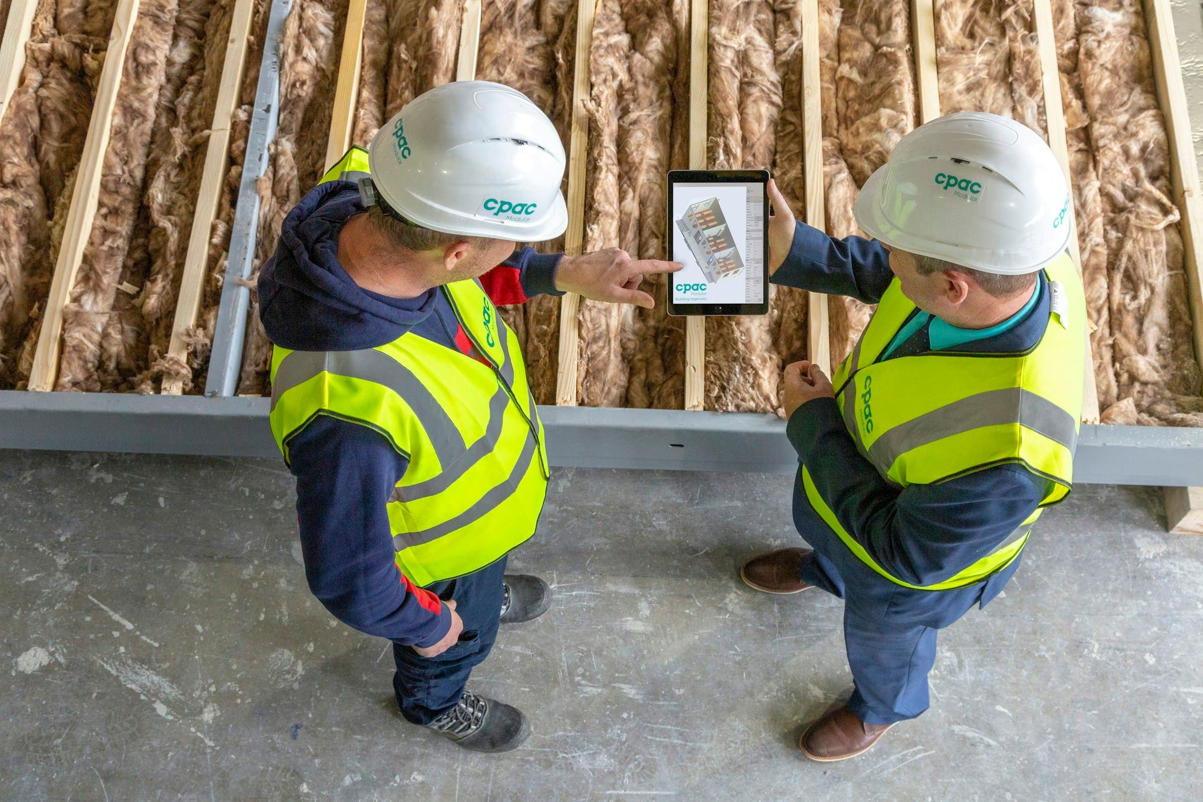 Two construction professionals reviewing plans on a tablet