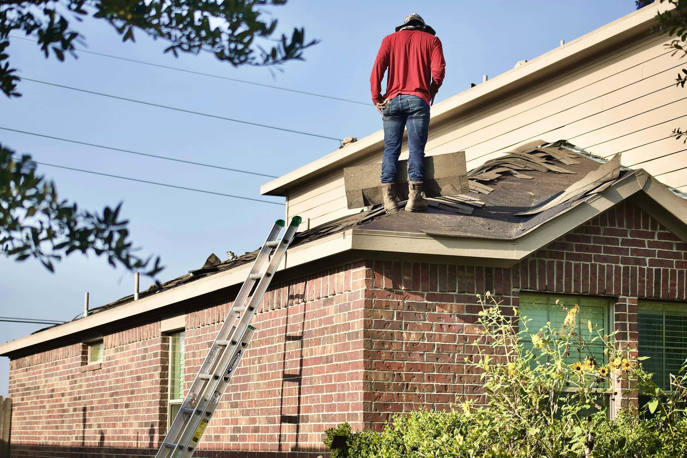 Roofer standing on a residential roof during an inspection